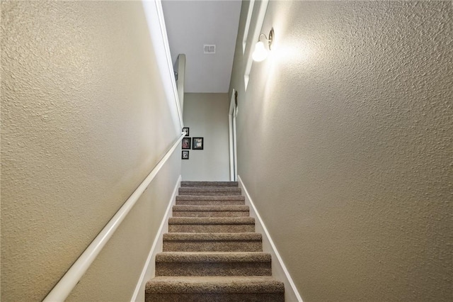 stairs featuring a textured wall