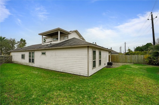 rear view of property featuring a yard and a fenced backyard