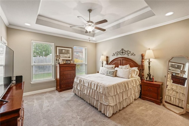 bedroom featuring light carpet, a tray ceiling, baseboards, and crown molding