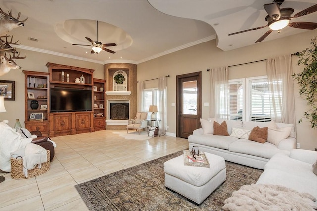 living room with a large fireplace, plenty of natural light, ornamental molding, and light tile patterned flooring