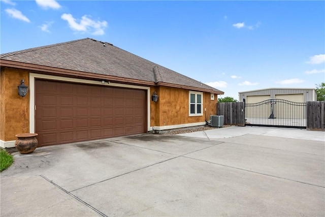 view of side of home with concrete driveway, a shingled roof, fence, and central air condition unit