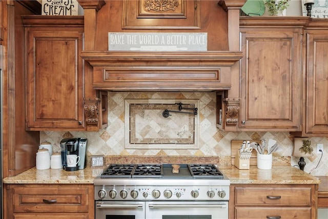 kitchen featuring light stone counters, brown cabinets, double oven range, and tasteful backsplash