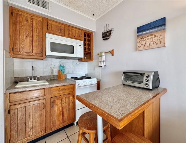 3938 Surfside Unit 3337, Corpus Christi, TX 78402 - kitchen featuring white appliances, ornamental molding, a textured ceiling, backsplash, and light tile patterned floors