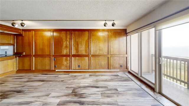 interior space featuring rail lighting and a textured ceiling