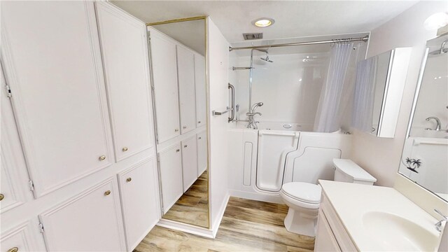 bathroom with toilet, vanity, and wood-type flooring