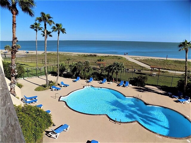 view of pool with a water view and a patio