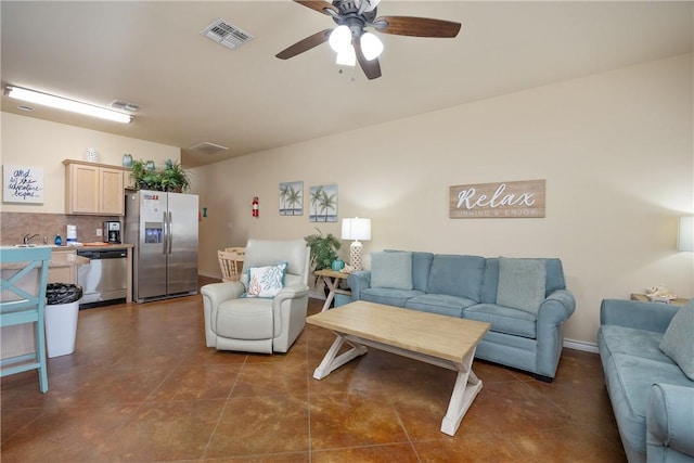 living room featuring ceiling fan and dark tile patterned floors