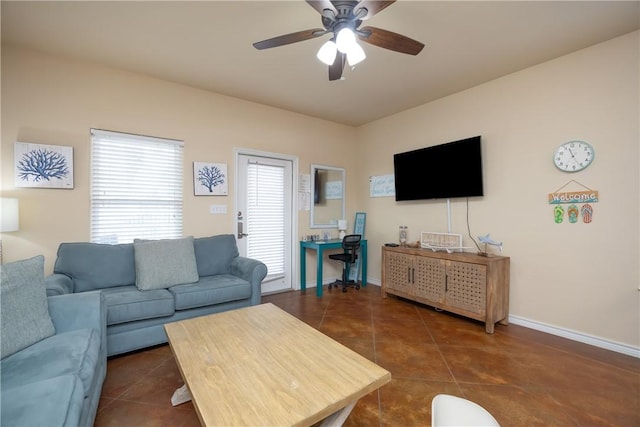 living room featuring ceiling fan and dark tile patterned flooring