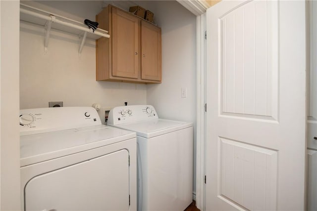 laundry area featuring washing machine and dryer and cabinets