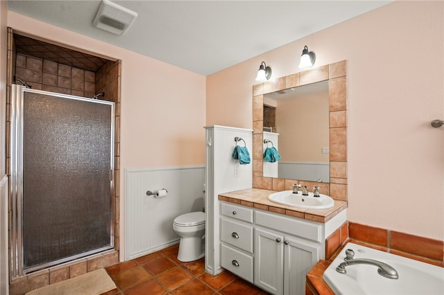 15746 Cuttysark St, Corpus Christi, TX 78418 - bathroom featuring a stall shower, vanity, toilet, a wainscoted wall, and a bath