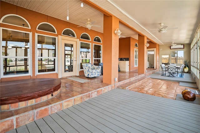 wooden terrace with ceiling fan and a covered hot tub