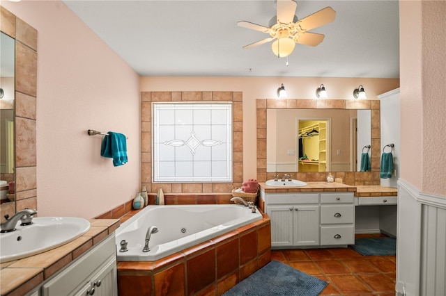 bathroom featuring tile patterned flooring, vanity, ceiling fan, and tiled tub