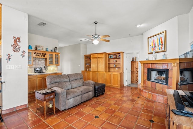 living room featuring a fireplace, ceiling fan, and tile patterned floors