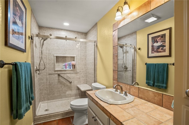 bathroom with toilet, vanity, tile patterned floors, and walk in shower