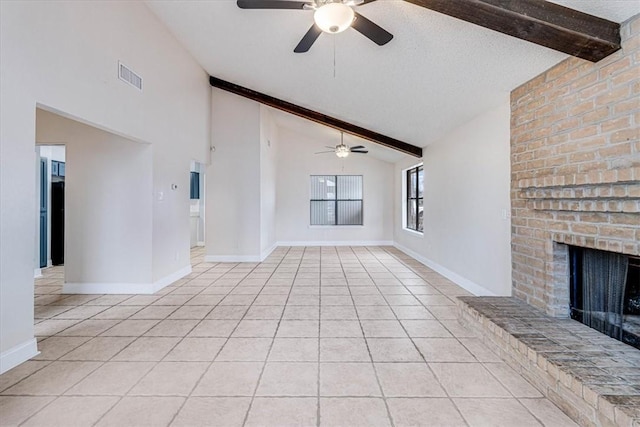 unfurnished living room featuring a textured ceiling, ceiling fan, beamed ceiling, a fireplace, and light tile patterned floors