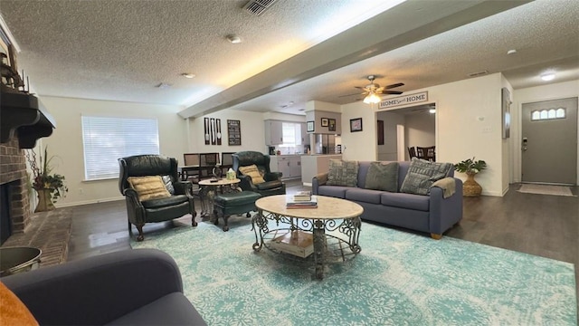 134 Daniel Moore St, Portland, TX 78374 - living room with a textured ceiling, a fireplace, wood finished floors, and a ceiling fan
