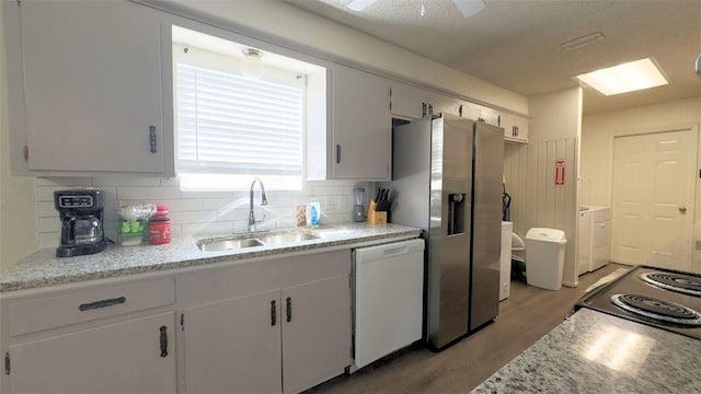 134 Daniel Moore St, Portland, TX 78374 - kitchen with white dishwasher, stainless steel fridge with ice dispenser, range with electric cooktop, washing machine and clothes dryer, and light wood-style floors