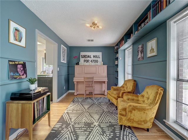 living area featuring hardwood / wood-style flooring and a textured ceiling