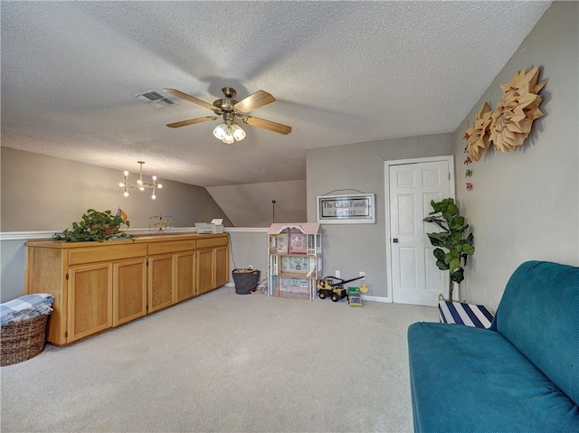 sitting room featuring a textured ceiling, lofted ceiling, light carpet, and ceiling fan