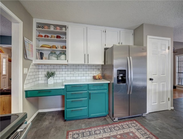 kitchen featuring stainless steel appliances, tasteful backsplash, a textured ceiling, blue cabinetry, and white cabinets