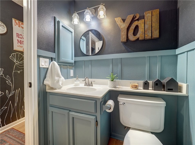 bathroom with hardwood / wood-style floors, vanity, and toilet