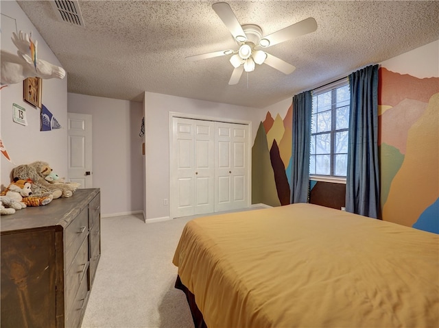 carpeted bedroom featuring ceiling fan, a textured ceiling, and a closet