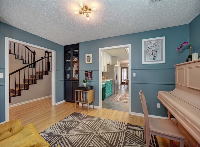 miscellaneous room with wood-type flooring and a textured ceiling