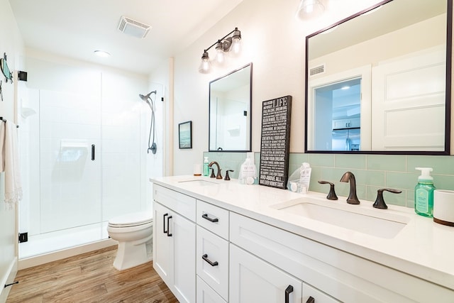 bathroom with vanity, backsplash, hardwood / wood-style flooring, and walk in shower