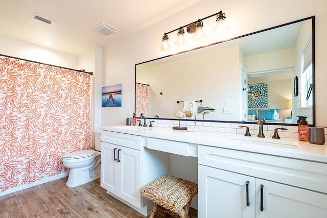 bathroom with hardwood / wood-style floors, vanity, and toilet