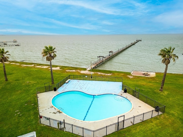 view of swimming pool with a yard and a water view