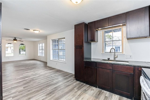 3033 Elgin St, Corpus Christi, TX 78405 - kitchen with light wood finished floors, dark brown cabinets, ceiling fan, open floor plan, and dark stone counters