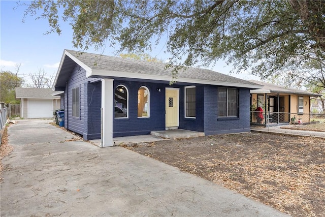 3033 Elgin St, Corpus Christi, TX 78405 - ranch-style home featuring asphalt driveway, brick siding, covered porch, and an outbuilding