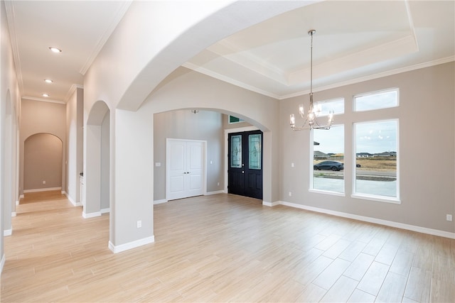 unfurnished room featuring a notable chandelier, light wood-type flooring, and french doors