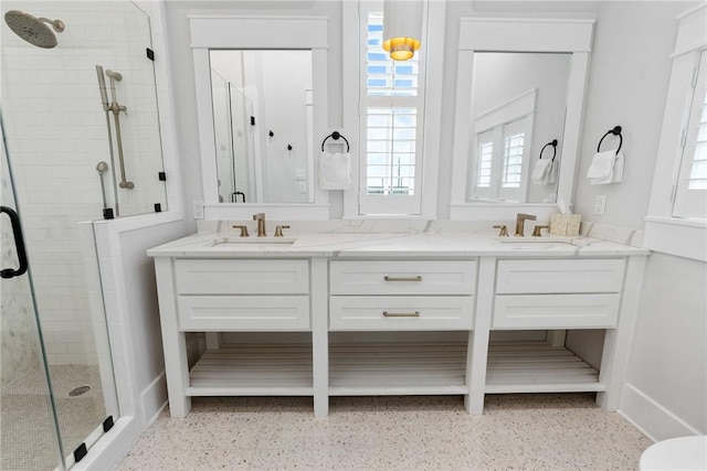 bathroom with double vanity, a stall shower, a wealth of natural light, and a sink