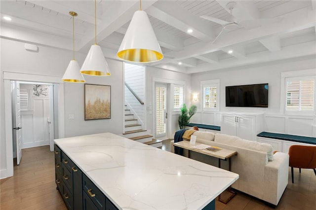 kitchen with beamed ceiling, a decorative wall, open floor plan, and light wood finished floors