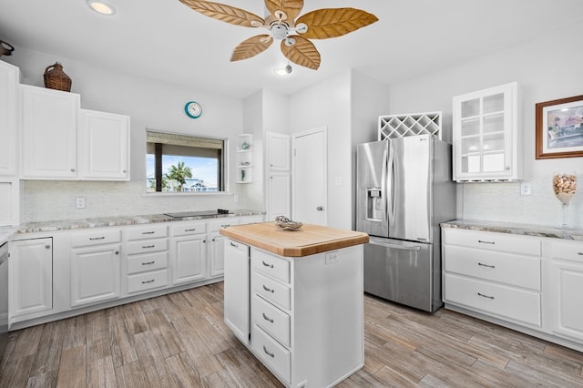 kitchen featuring light wood finished floors, stainless steel appliances, glass insert cabinets, white cabinetry, and a kitchen island