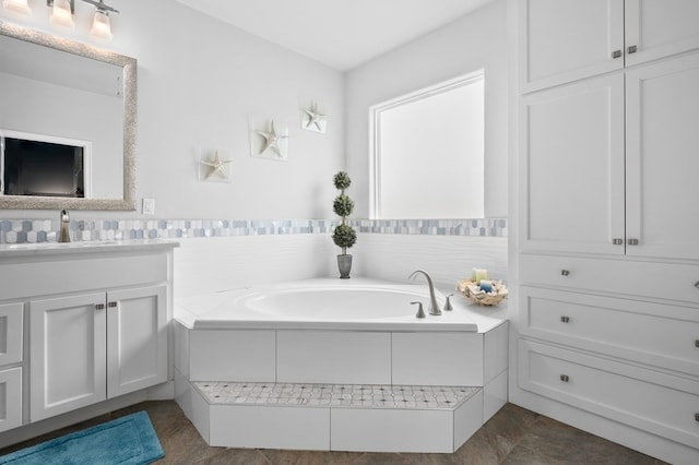 bathroom featuring a garden tub and vanity