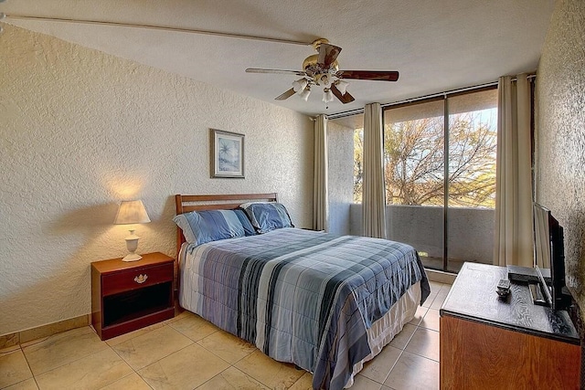 bedroom featuring access to exterior, light tile patterned floors, a textured ceiling, and ceiling fan