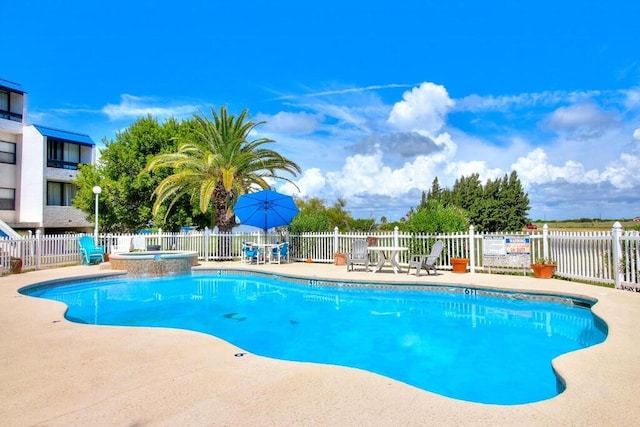 view of pool with a patio area and a hot tub