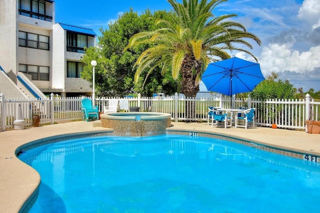 view of pool with a patio area and an in ground hot tub