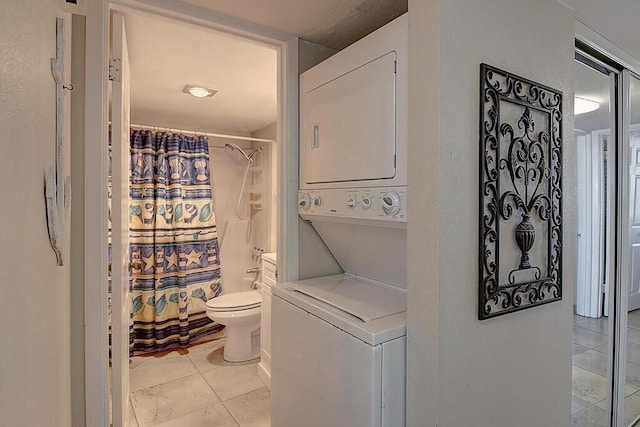 bathroom featuring tile patterned flooring, stacked washing maching and dryer, toilet, and a shower with curtain