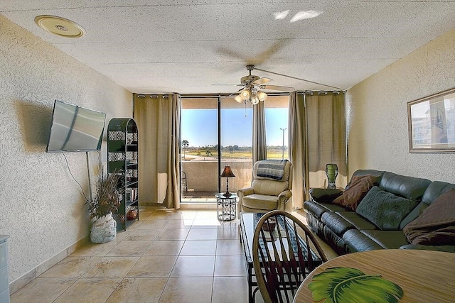 living room featuring expansive windows, light tile patterned floors, and ceiling fan