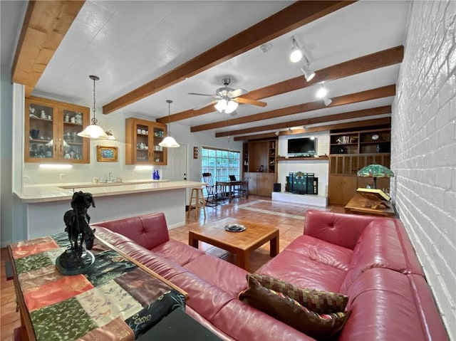 tiled living room featuring sink, beamed ceiling, ceiling fan, rail lighting, and built in shelves