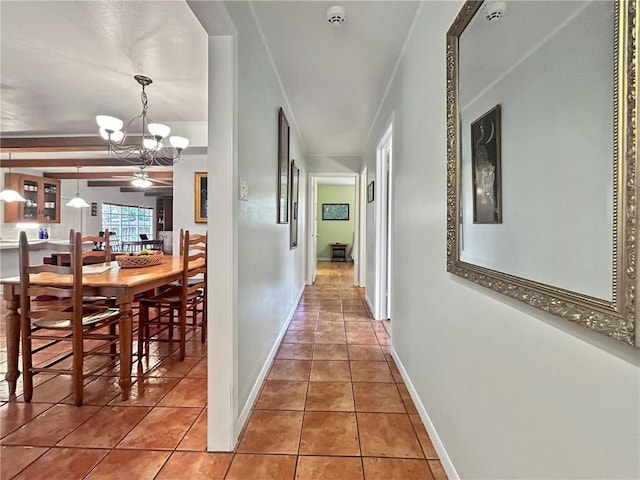 corridor featuring tile patterned flooring and a chandelier