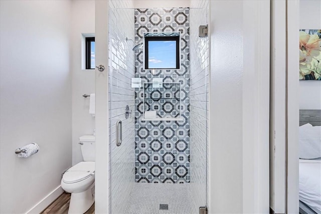 full bath featuring a shower stall, baseboards, and toilet
