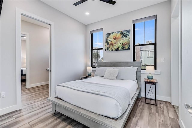 bedroom featuring baseboards, light wood-type flooring, recessed lighting, and a ceiling fan
