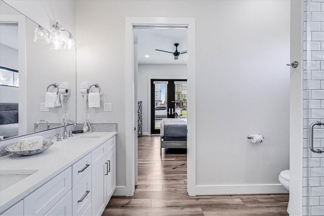 full bathroom featuring a sink, a ceiling fan, connected bathroom, and wood finished floors