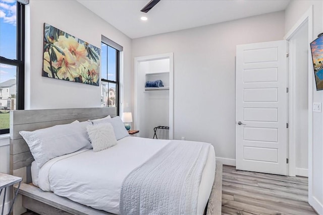 bedroom featuring a closet, recessed lighting, light wood-type flooring, and baseboards