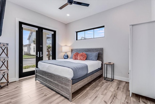 bedroom featuring access to exterior, light wood-style floors, multiple windows, and baseboards