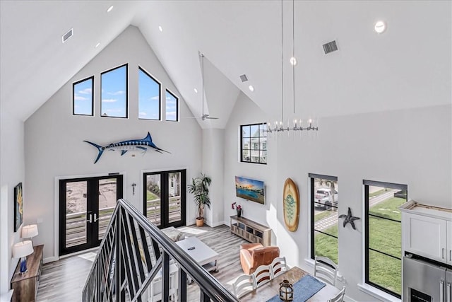 stairs with french doors, visible vents, and wood finished floors